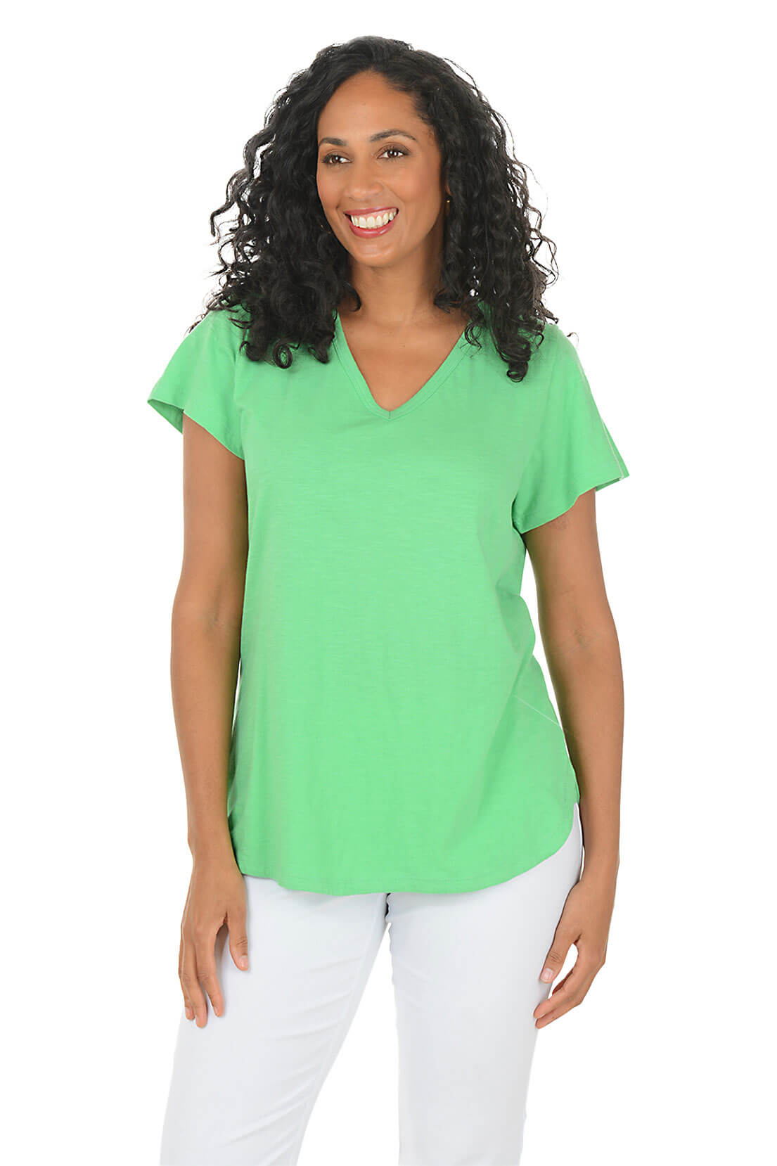 Woman wearing a green top and white pants on a white background