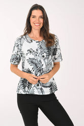 Woman wearing a black and white floral print top on a white background