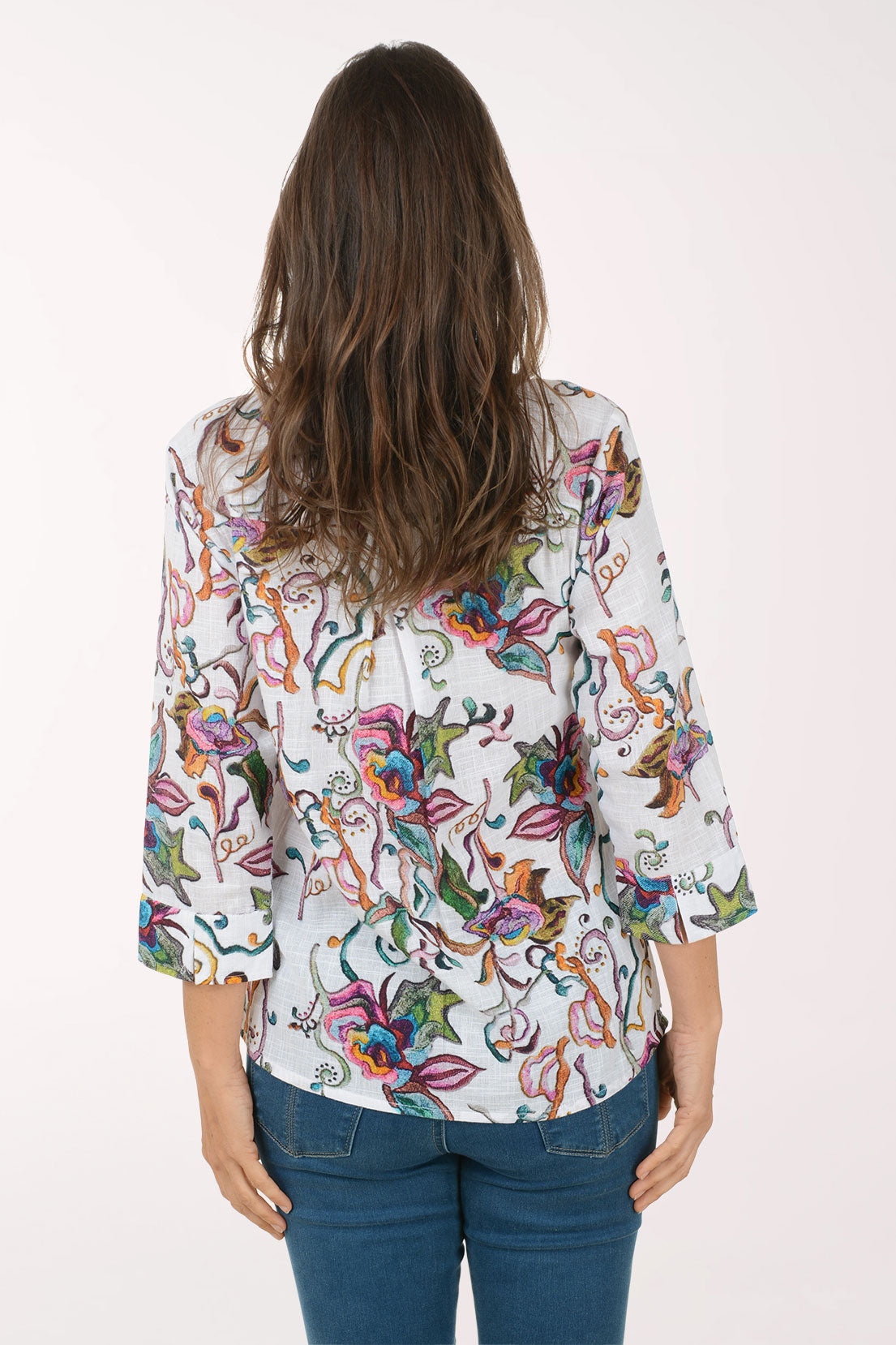 Woman wearing a colorful floral blouse on a white background
