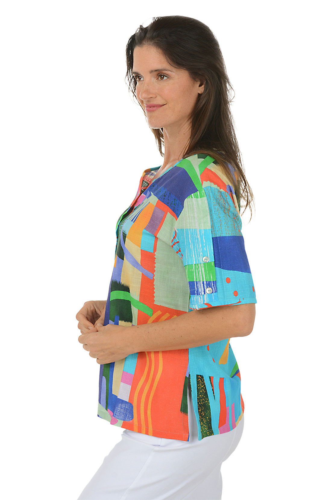 Woman wearing a colorful abstract patterned top on a white background. Side shot.