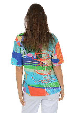 Woman wearing a colorful abstract patterned top on a white background. Back shot.