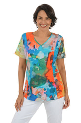 Woman wearing a colorful abstract patterned top on a white background.
