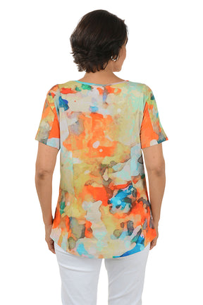 Woman wearing a colorful abstract patterned top on a white background. Back shot.