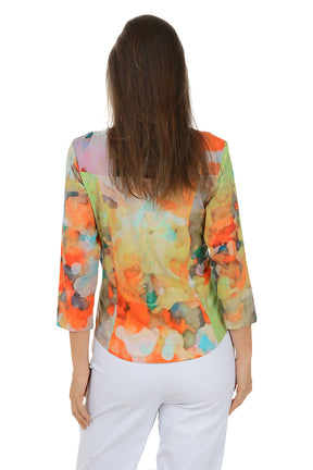 Woman wearing a colorful floral blouse with white pants on a white background. Back shot.