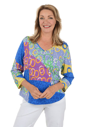 Woman wearing a colorful patterned top on a white background.