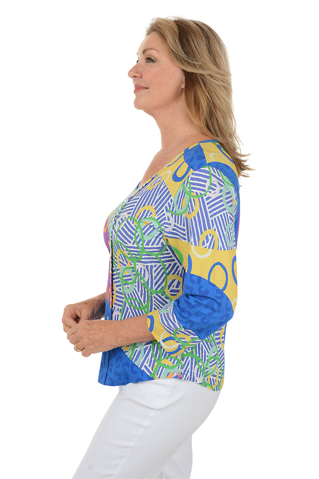 Woman wearing a colorful patterned top on a white background. Side shot.
