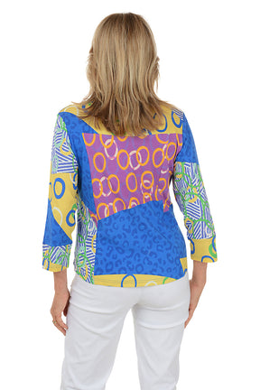 Woman wearing a colorful patterned top on a white background. Back shot.