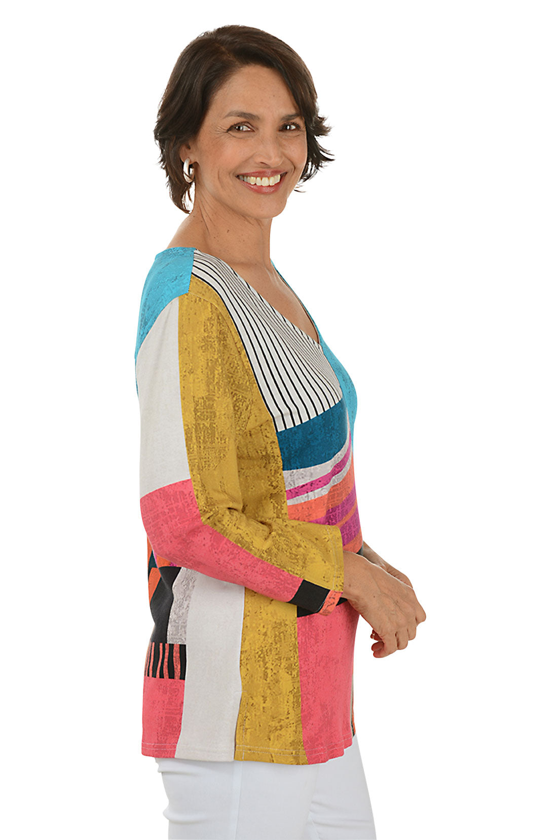 Woman wearing a colorful patterned top on a white background. Side shot.