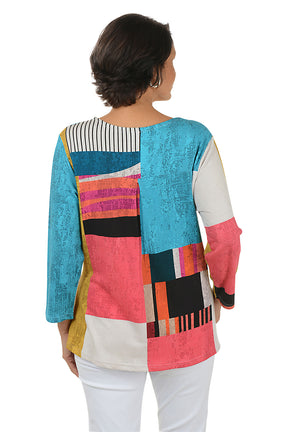 Woman wearing a colorful patterned top on a white background. Back shot.