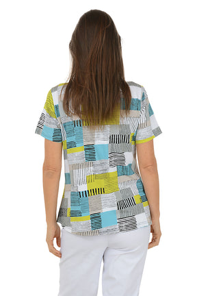 Woman wearing a patterned blouse with a white background. Back shot.