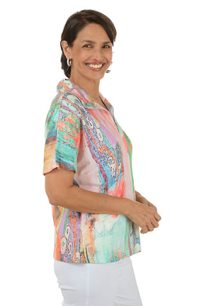Woman wearing a colorful patterned blouse on a white background