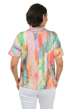 Woman wearing a colorful patterned blouse with a white background