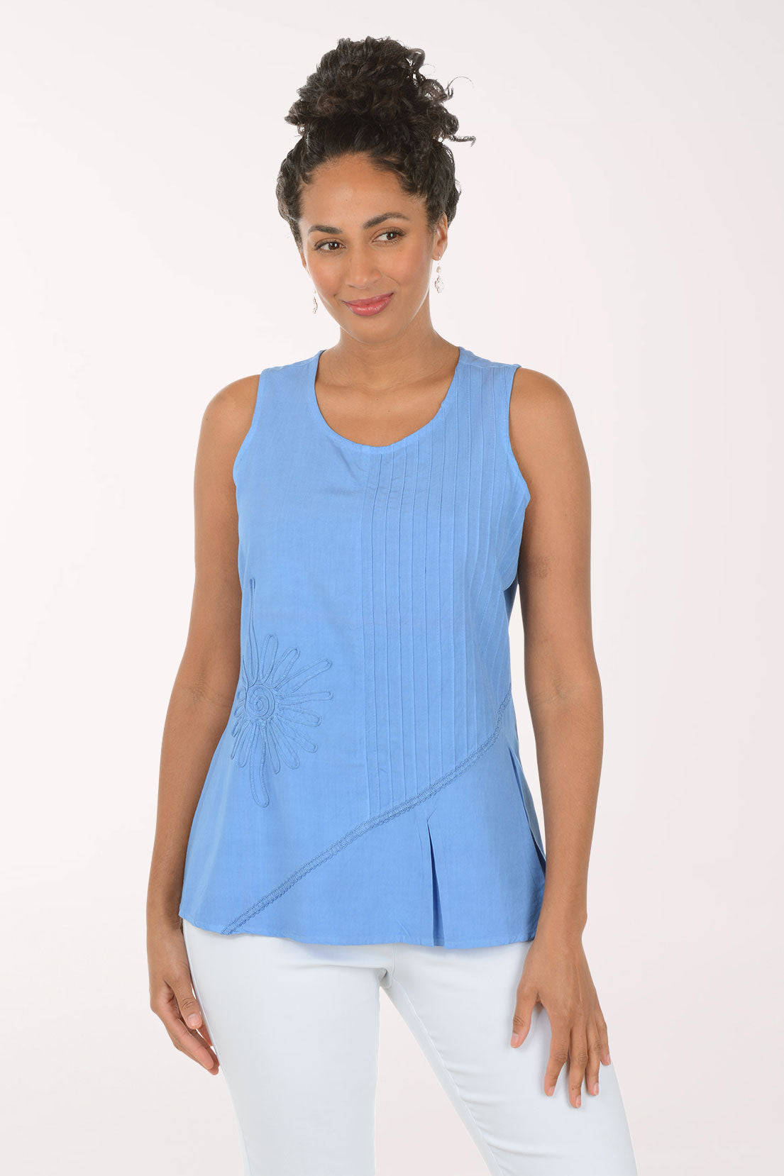 Woman wearing a blue sleeveless top with a white background