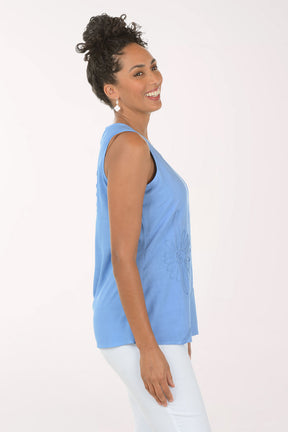 Woman wearing a blue sleeveless top with a white background