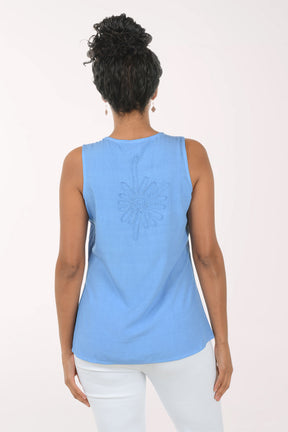 Woman wearing a blue sleeveless top with a white background