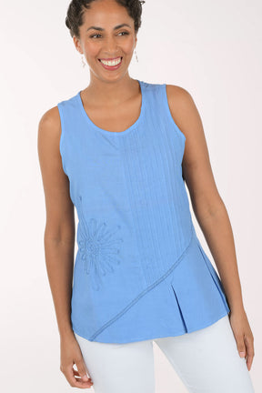 Woman wearing a blue sleeveless top with a white background
