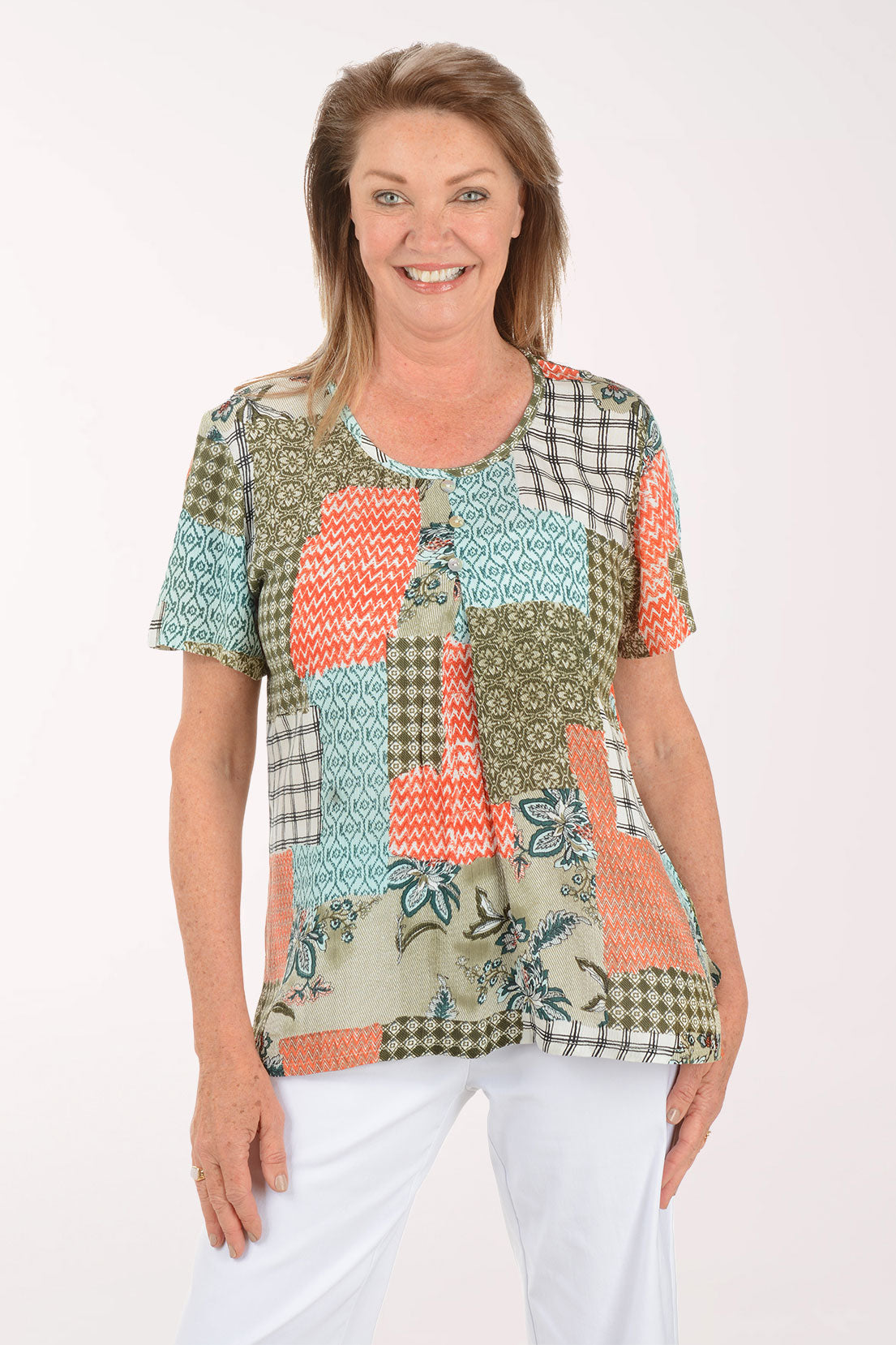 Woman wearing a colorful patchwork top on a white background