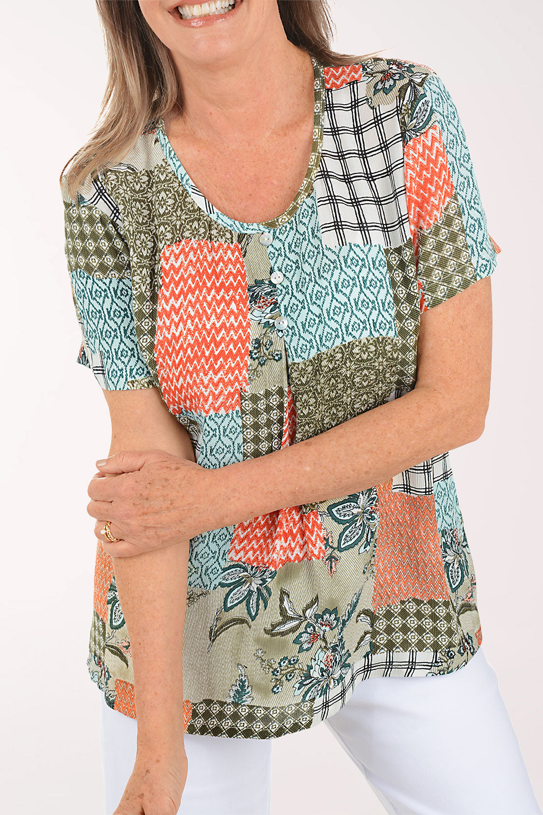 Woman wearing a colorful patchwork top on a white background