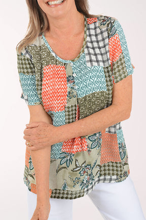 Woman wearing a colorful patchwork top on a white background