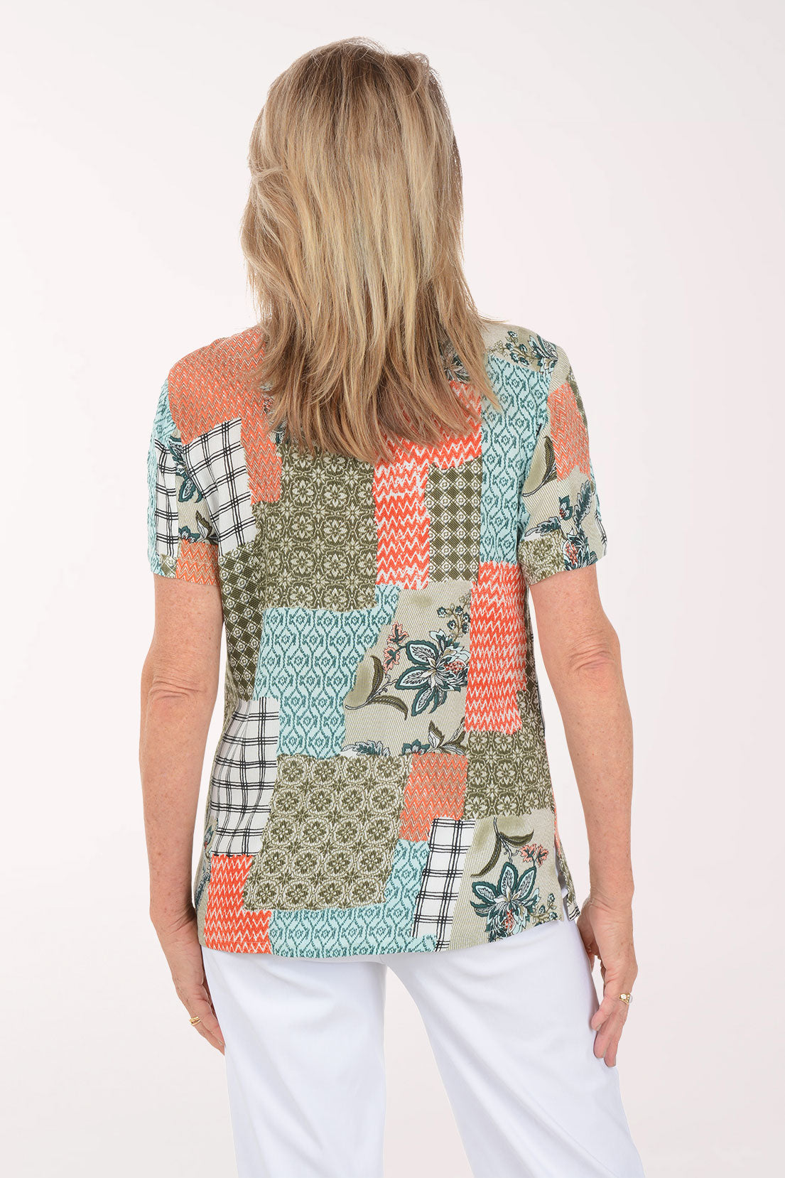 Woman wearing a colorful patchwork top on a white background