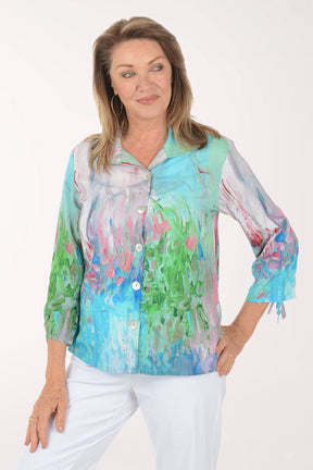 Woman wearing a colorful blouse with abstract patterns on a white background