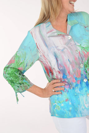 Woman wearing a colorful blouse with abstract patterns on a white background