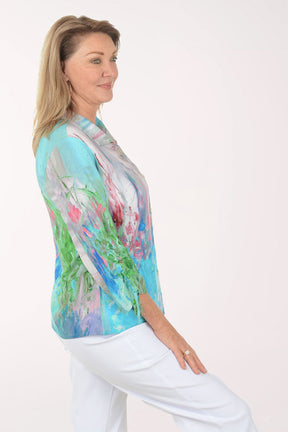 Woman wearing a colorful blouse with abstract patterns on a white background