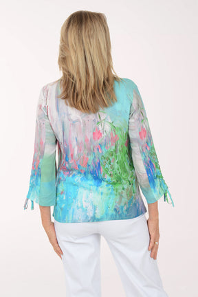 Woman wearing a colorful blouse with abstract patterns on a white background