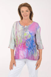 Woman wearing a colorful blouse with abstract design on a white background