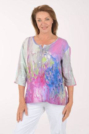 Woman wearing a colorful blouse with abstract design on a white background