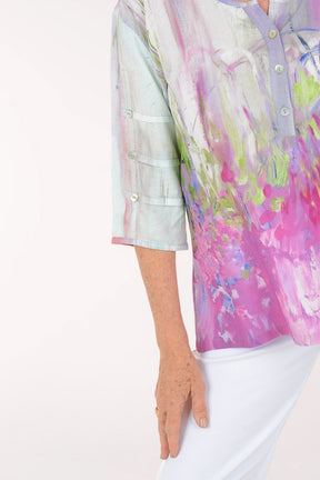 Woman wearing a colorful blouse with abstract design on a white background