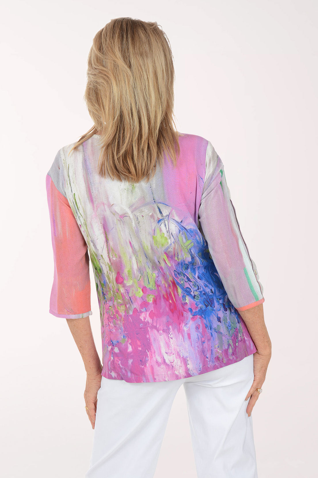 Woman wearing a colorful blouse with abstract design on a white background