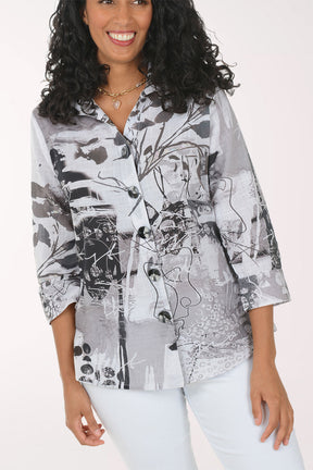 Woman wearing a patterned shirt and white pants on a white background