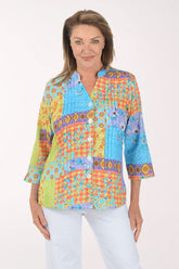 Woman wearing a colorful patterned blouse on a white background