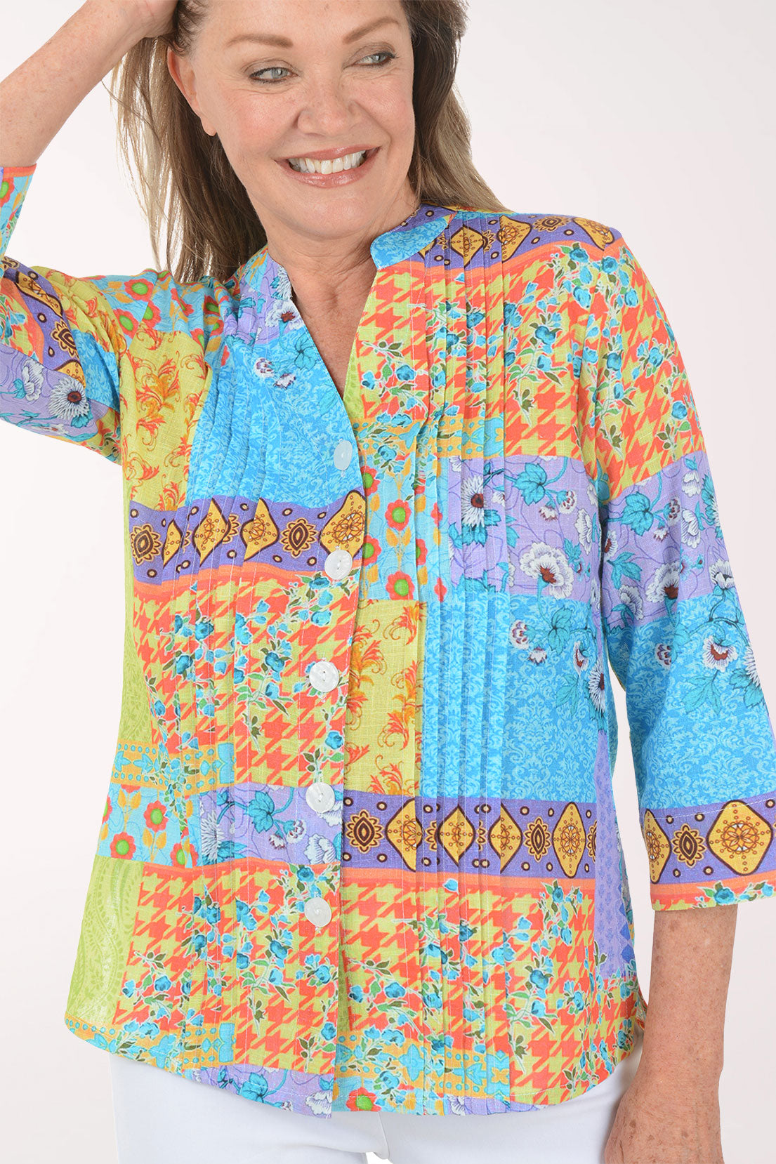 Woman wearing a colorful patterned blouse on a white background