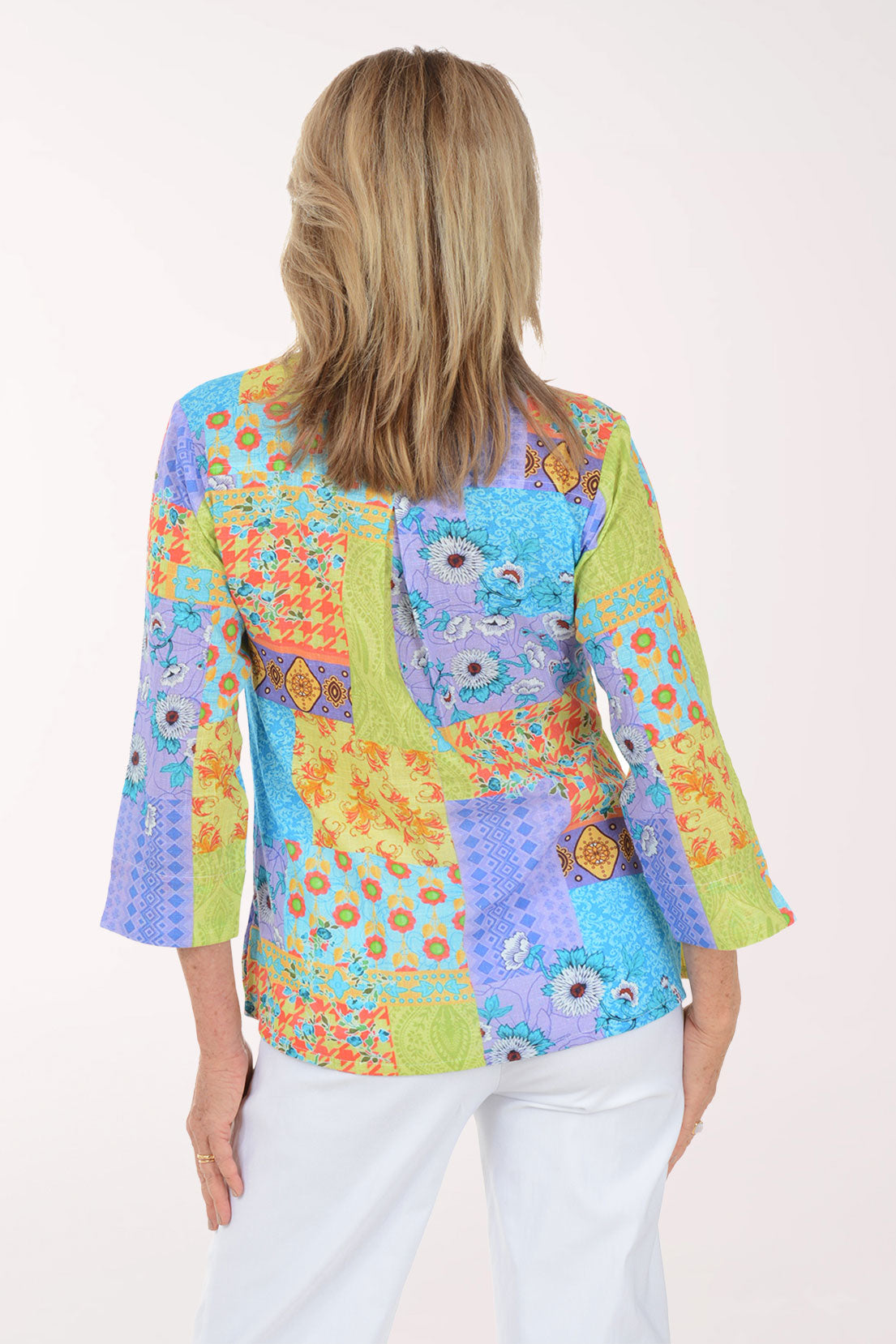 Woman wearing a colorful patterned blouse on a white background