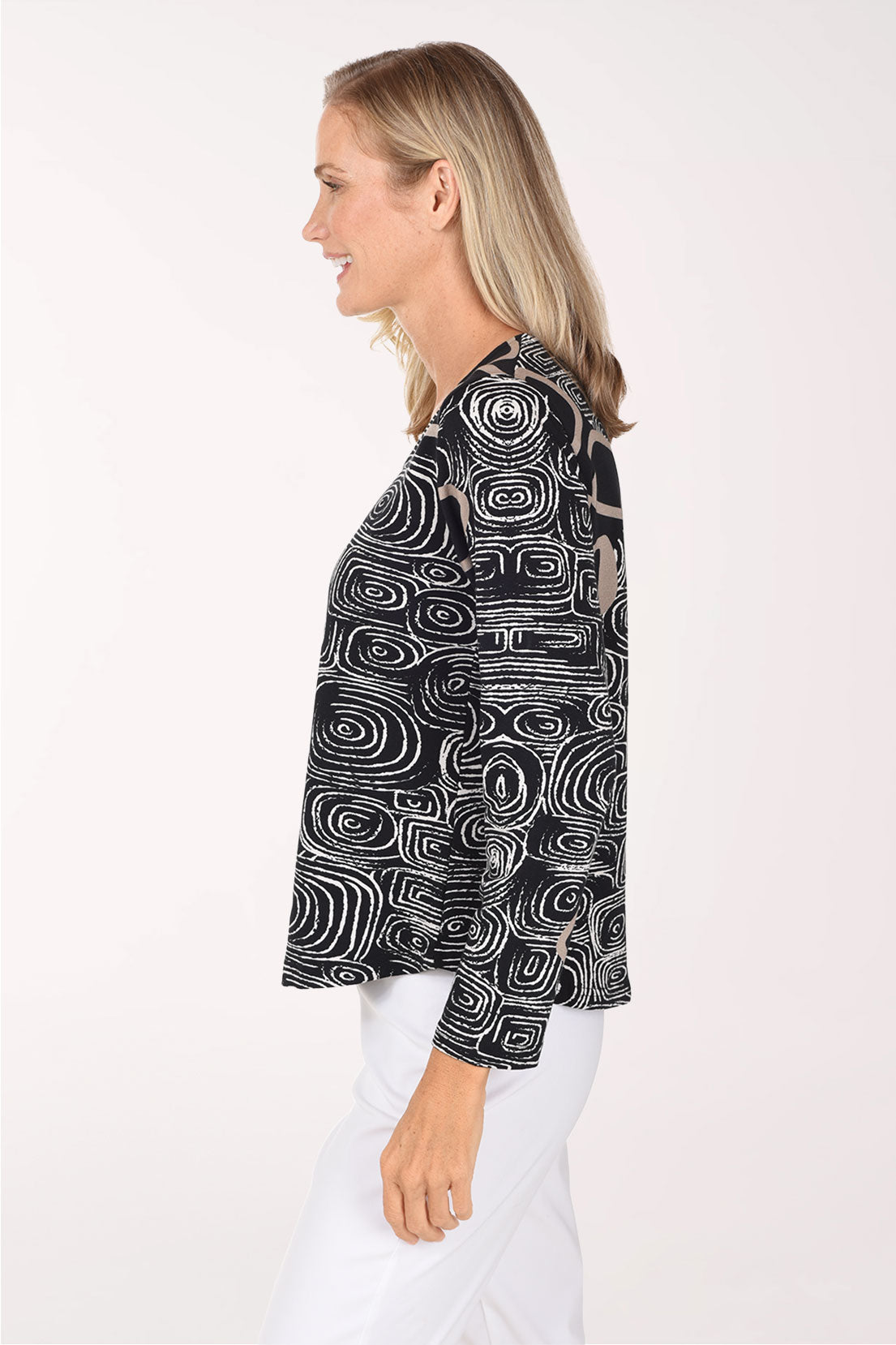 A woman wearing a black long sleeve shirt with a white swirl and square abstract print
