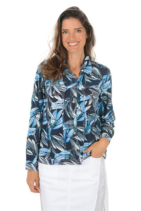 Woman wearing a blue and black leaf-patterned jacket on a white background.
