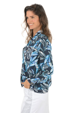 Woman wearing a blue and black leaf-patterned jacket on a white background. Side shot.