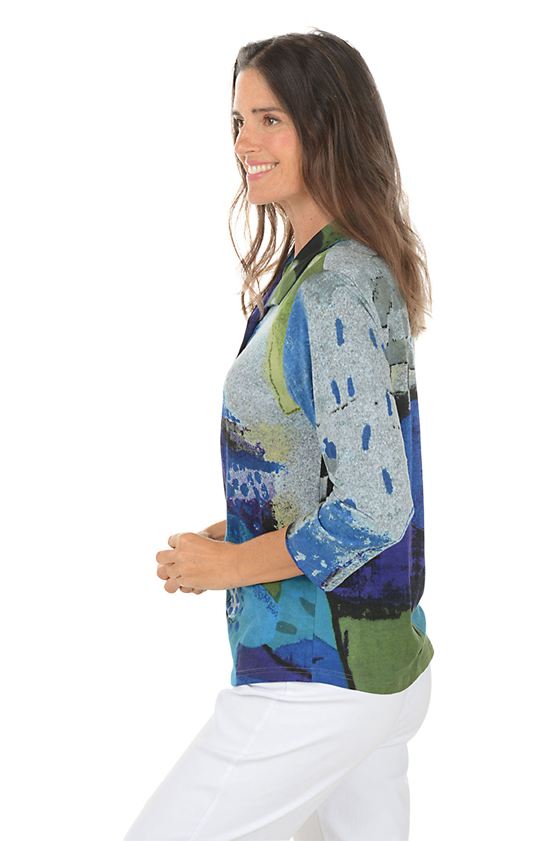 Woman wearing a blue multi colorful floral blouse with a white background. Side shot.