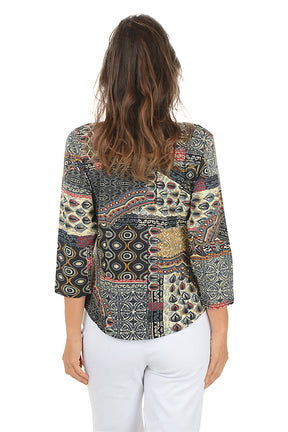 Woman wearing a 3/4 sleeve paisley patterned blouse and white pants on a white background. Back shot.