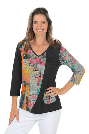 Woman wearing a black top with colorful patterned sleeves on a white background.