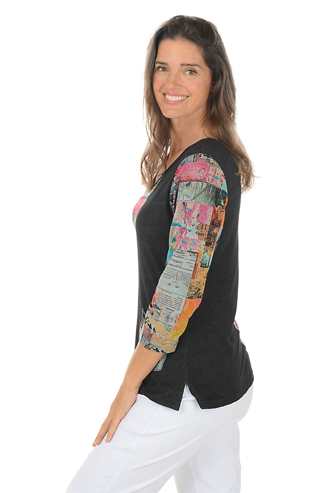 Woman wearing a black top with colorful patterned sleeves on a white background. Side shot.