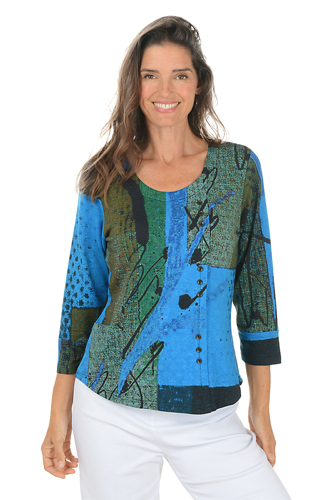 Woman wearing a colorful patterned top with blue and green design on a white background.