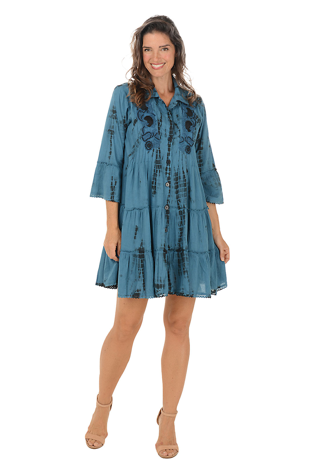 Woman wearing a blue dress with floral patterns on a white background. Second front shot.