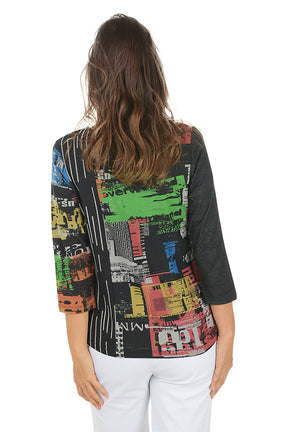 Woman wearing a 3/4 sleeve colorful typesetting patterned top with a white background. Back shot.
