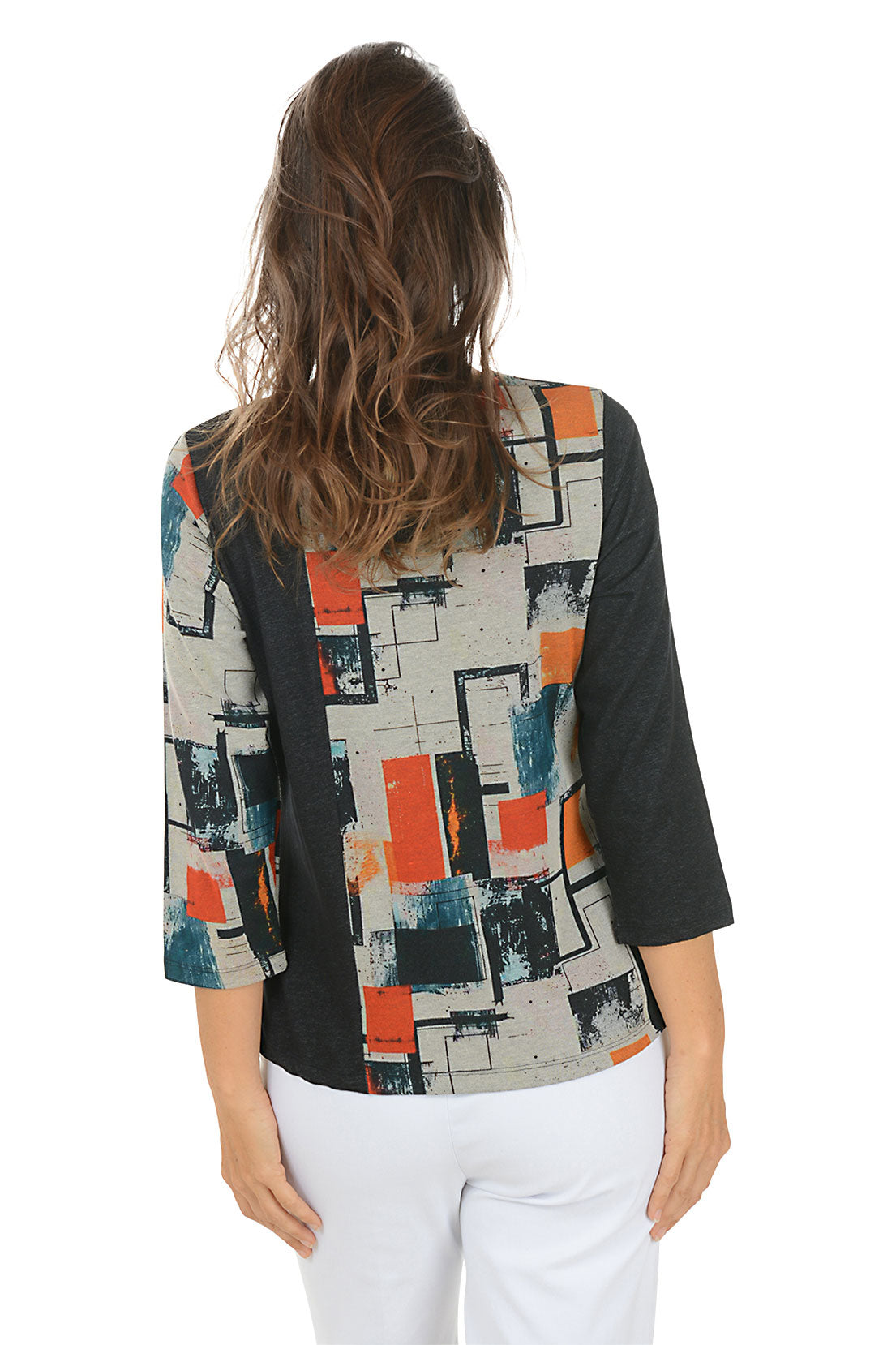 Woman wearing a 3/4 sleeve black and multicolor abstract patterned top with white pants on a white background. Back shot.