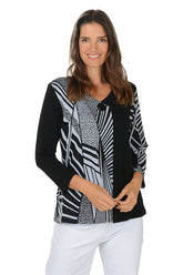 Woman wearing a black and white patterned blouse with a white background.