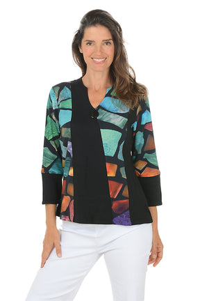 Woman wearing a 3/4 sleeve patchwork patterned top with a contrasting cuff on a white background.