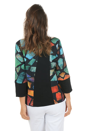 Woman wearing a 3/4 sleeve patchwork patterned top with a contrasting cuff on a white background. Back shot.